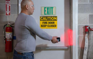 Fire and Life Safety Inspections - Man using scanner on a fire door