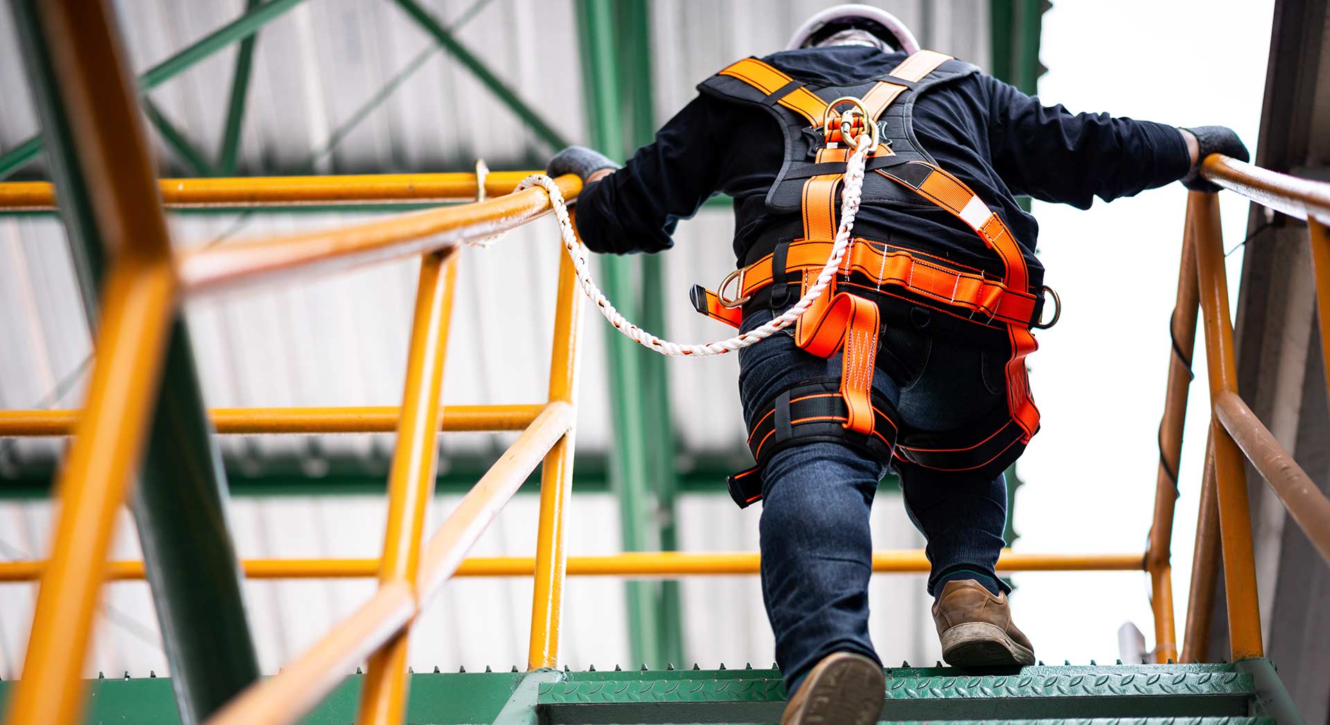 worker with gear on walking up a set of stairs 