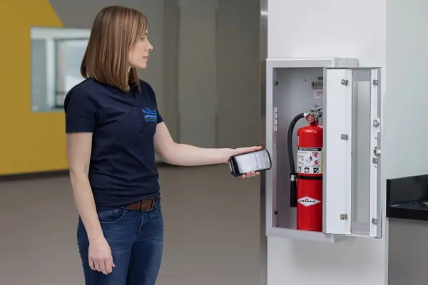 woman scanning fire extinguisher fire inspection software for fire extinguisher being used